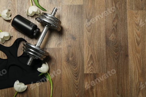 Preview: Sportswear and accessories, with flowers, on a wooden background.