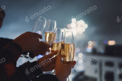 Visualização: Quatro taças de champanhe contra o céu enfumaçado com fogos de artifício