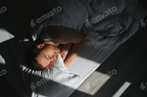 Preview: Cute young man sleeping on bed