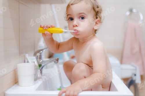 Preview: Adorable Toddler Brushing Teeth in the Bathroom Sink