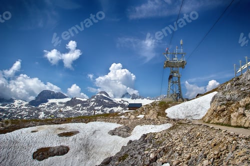 Preview: Cable car tower at the Dachstein Mountains in Austria, against a cloudy blue sky