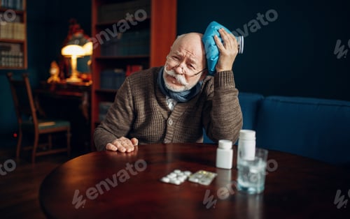 Preview: Sick elderly man puts ice on his head, headache