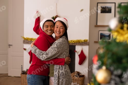 Visualização: Duas amigas felizes e diversas em chapéus de Papai Noel tirando fotos na época do Natal