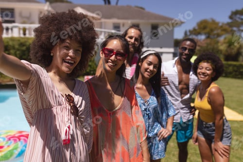 Preview: Portrait of diverse group of friends taking selfie at a pool party