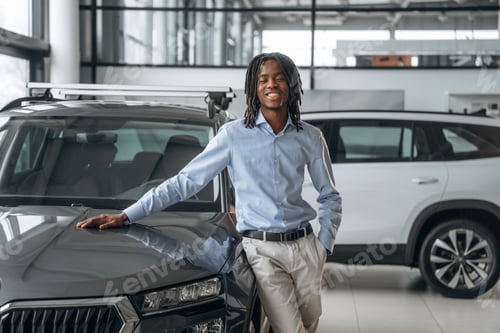 Preview: Leaning on the vehicle. Car seller, businessman is standing in automobile salon