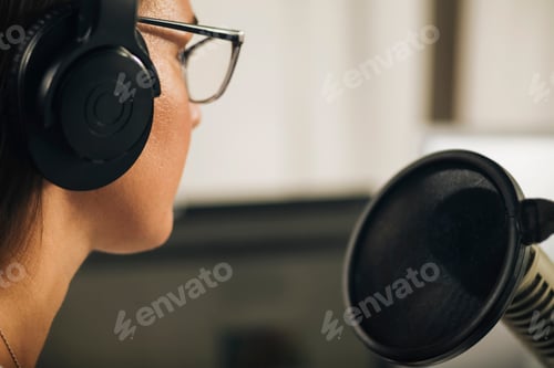Preview: Young Woman Hosting a Talk Show from Her Studio, Wearing Headphones, Talking to the Microphone