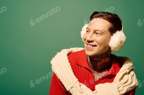 Preview: Fashionable young man with tattoos sporting winter attire against a vibrant green backdrop