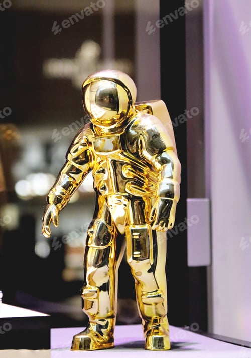 Preview: Golden figurine of an astronaut on a light surface close-up
