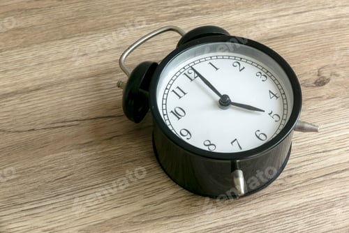 Preview: Embracing the Early Hours: The Significance of a 5 AM Alarm Clock on a Wooden Table