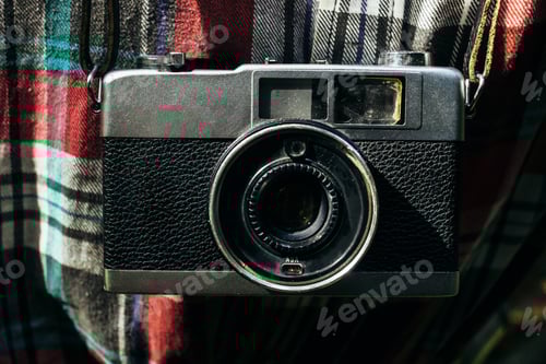 Preview: stylish analog photo camera on traveler in sunny forest in the mountains