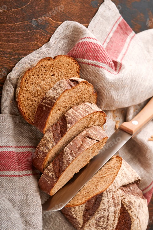 Preview: Fresh homemade rye bread. Traditional spelled sourdough bread cut into slices on a rustic wooden bac