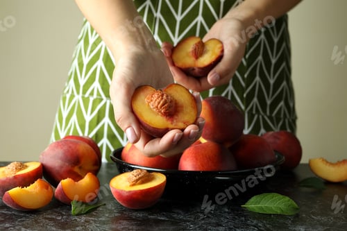 Preview: Girl in green apron holds ripe peach fruits