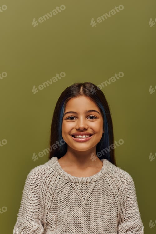 Preview: Portrait of positive and stylish brunette preteen girl with dyed hair wearing modern cozy knitted