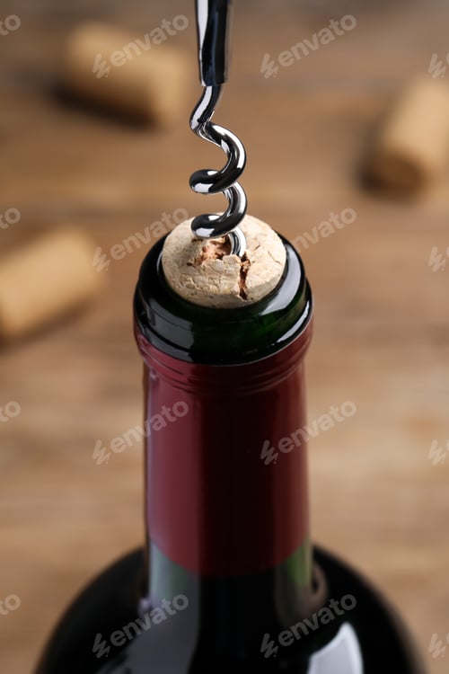 Preview: Opening wine bottle with corkscrew on table, closeup