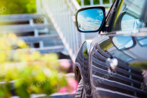Preview: Car mirror. Reflection of sunny blue sky at the car side mirrow