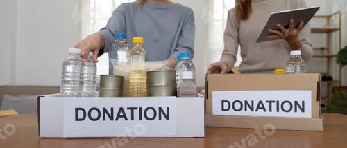 Preview: Volunteer preparing free foodstuff rations for poor people. Charity two woman of the community work