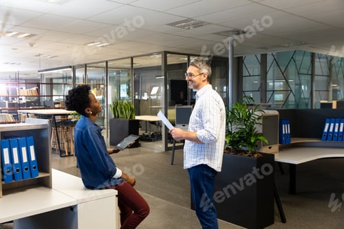 Preview: Happy multiracial professionals planning while discussing during meeting at modern workplace