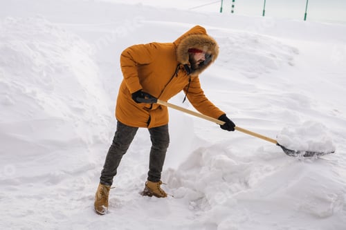 Preview: Man cleaning snow from sidewalk and using snow shovel. Winter season