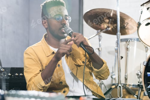 Preview: Man With Microphone Recording Music in Studio