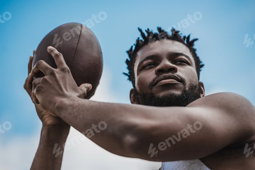 Preview: young handsome african american male football player with ball