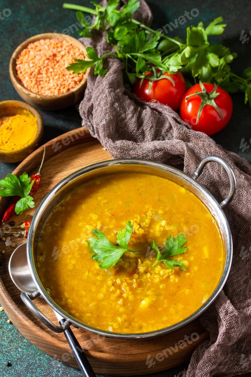 Preview: Indian cuisine. Traditional Indian spicy lentil puree soup with herbs on a dark background.