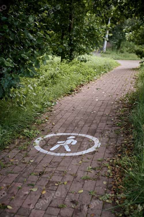 Preview: Serene brick path in lush green park signifies walking trail