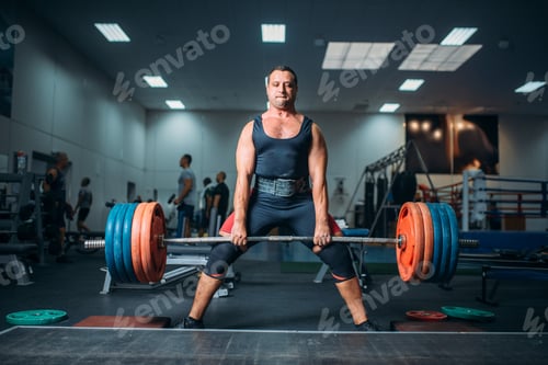 Preview: Weightlifter doing exercise with barbell, deadlift