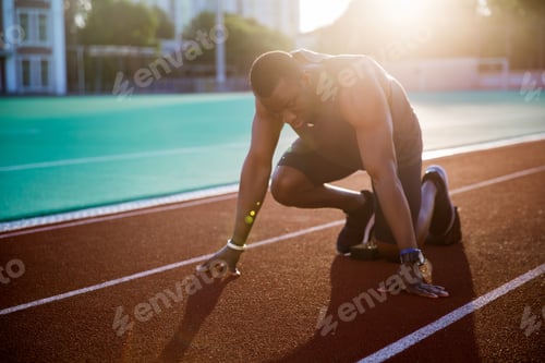 Preview: Young muscular concentrated athlete at the start