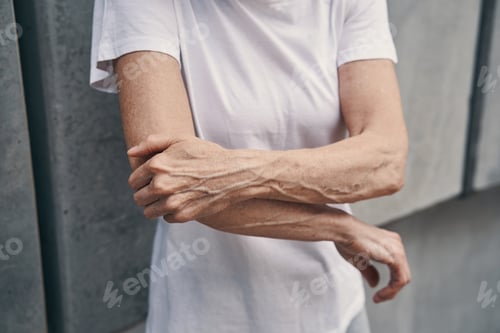 Preview: Mature sportswoman feeling pain in arm while jogging