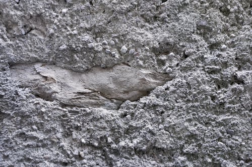 Preview: The Rough Textured Background From Grained Stones And With One Big Stone Of Gray Color