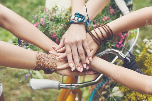 Hands Stacked Together near Decorated Bicycle