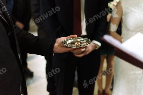 Preview: priest blessing luxury wedding rings in the old church