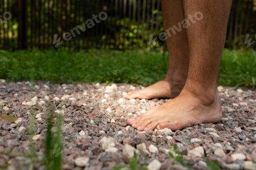 Preview: Men's bare feet on small stones