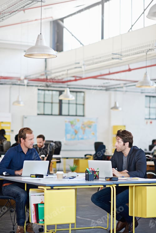 Preview: Here, we get creative. Shot of a coworkers sitting at laptops in a large office.