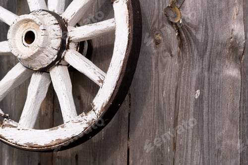 Preview: An old wooden carriage wheel hanging on the barn wall