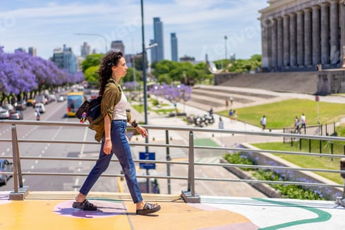 Preview: Confident woman strolling along a walkway in a lively city