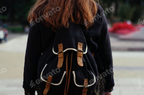 Preview: Back view of young brunette woman walking. Woman with rucksack in the city. Back to school,