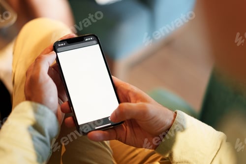 Preview: Confident businessman using smartphone sitting in restaurant