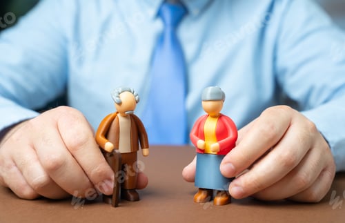 Preview: A man holding figurines of pensioners. An official and elderly people of retirement age