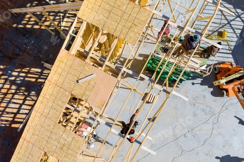 Preview: Building contractor carpenter placing new home wood engineered trusses on a residential under