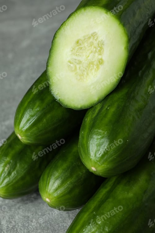 Ripe cucumbers on gray background, close up