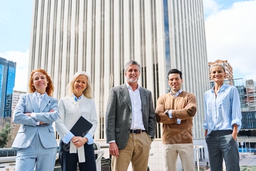 Preview: Business people standing together looking at camera