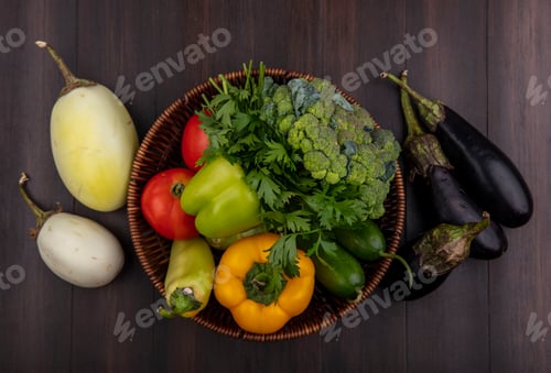 Preview: top view white and black eggplant with broccoli bell peppers cucumbers and tomatoes in basket on