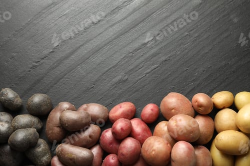 Preview: Different types of potatoes on black table, flat lay. Space for text