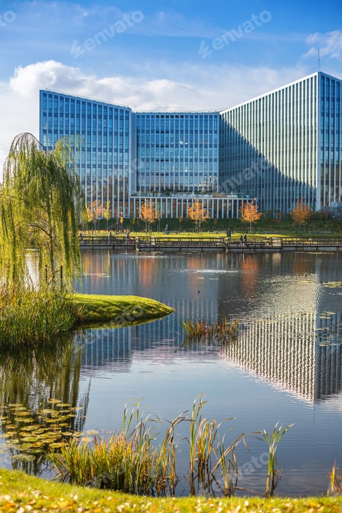 Preview: A modern architectural structure with a glass facade is framed by lush vegetation