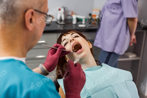 Preview: Young pretty woman patient in dental clinic having dental check and treatment