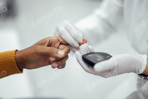 Preview: Doctor squeezing patient's finger for a drop of blood for measuring blood sugar level.