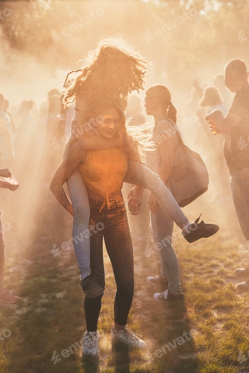 Preview: Portrait of happy smiling young girls with colorful paints on faces and clothes