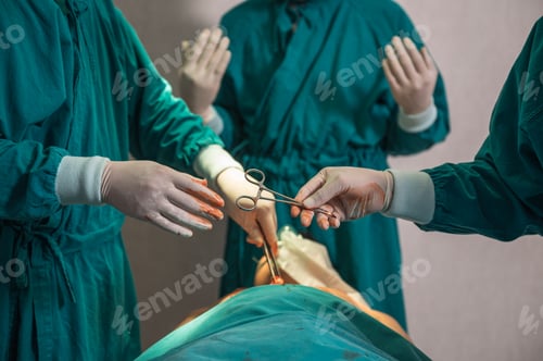 Preview: Surgeons team performing surgery and passing surgical scissors on injured patient in operating room