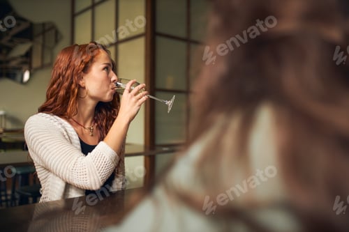 Preview: Young woman drinking wine in bar